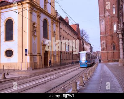 Paesaggio invernale con neve sul terreno e il treno elettrico o il tram che passa. Foto Stock