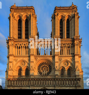 Dettagli della facciata principale della cattedrale di Notre Dame de Paris facciata con il più antico rosone e ornato tracery nella calda luce del tramonto Foto Stock