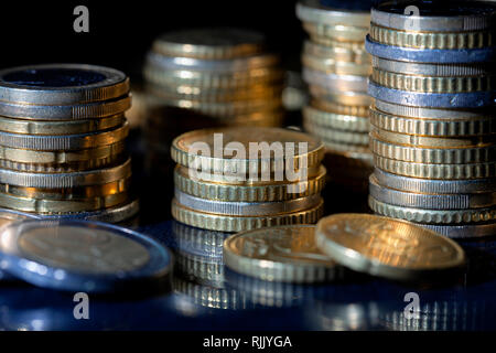 Un sacco di monete in euro e centesimi su sfondo nero. Foto Stock