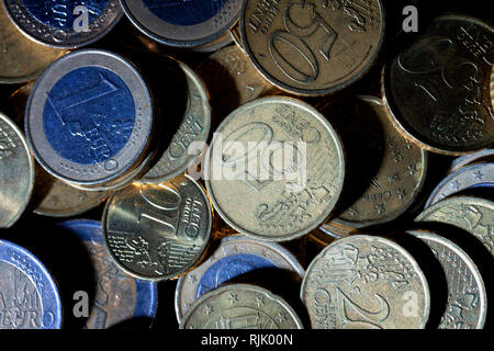 Un sacco di monete in euro e centesimi su sfondo nero. Foto Stock