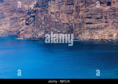 Pura seacliffs di Los Gigantes con cuciti aspre pareti rocciose incontrano la calma blu oceano atlantico sulla costa occidentale di Tenerife, Isole Canarie, Spagna Foto Stock