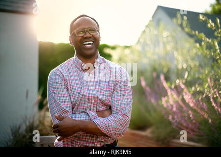 Uomo sorridente in giardino. Foto Stock