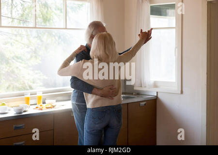 Età giovane marito e moglie dancing in cucina Foto Stock