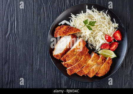 Tonkatsu - panko panate fritte cotoletta di maiale. Fritte lombo di maiale Cotoletta con fresca insalata di cavolo, pomodori e fettine di lime, cucina Giapponese, fla Foto Stock