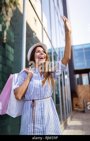 Shopping e turismo concept. Felice giovani oman con borse per lo shopping Foto Stock