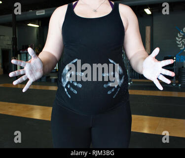 Pancia in gravidanza con chalk mani Foto Stock