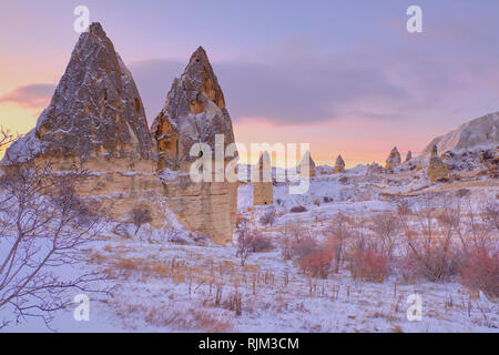 Formazione di roccia in Cappadocia (Valle dei piccioni) a seguito di una pesante caduta di neve. Tutto coperto in puro bianco della neve sotto il cielo blu Foto Stock