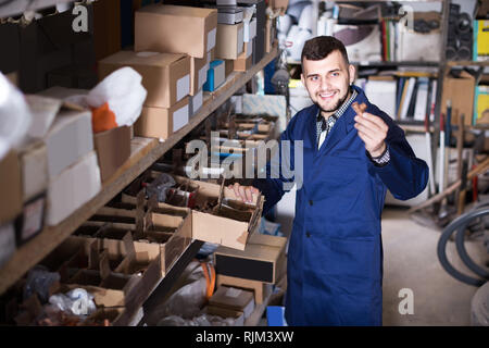 Lavoratore positivo controllo piccoli dettagli per ingegneria sanitaria in officina Foto Stock