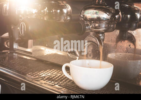 Macchina da caffè la preparazione di caffè in tazza bianca. Foto Stock