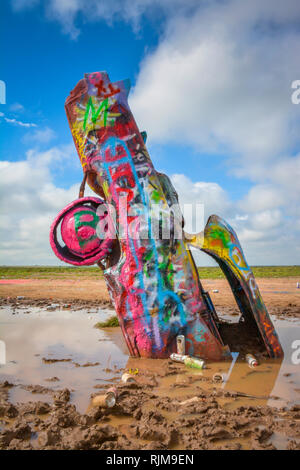 Cadillac Ranch è un arte di installazione compresa di vecchie Cadillac semi-interrato, naso verso il basso e verniciato a spruzzo quotidianamente dai visitatori vicino Amarillo, TX Foto Stock