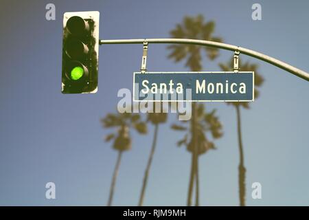 In stile retrò Santa Monica Boulevard cartello stradale con defocalizzata palme in background Foto Stock