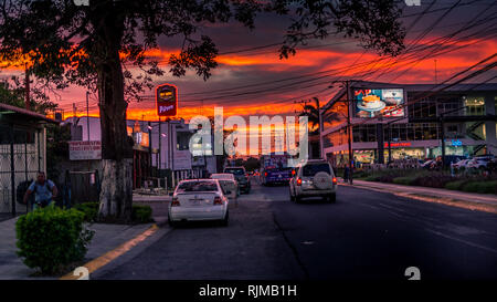 Una foto di una strada trafficata in Santa Ana, Costa Rica durante una bella e romantica al tramonto. Presa accanto alla Santa Ana centro città. Foto Stock