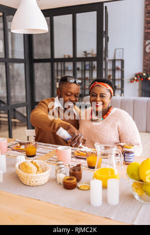 Felice coppia positiva che godono di una gustosa prima colazione Foto Stock