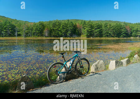 Mountain bike parcheggiata su una strada carrozzabile la bordatura di Eagle Lake nel Parco Nazionale di Acadia, Maine, Stati Uniti d'America. Foto Stock