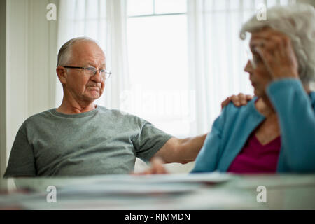 Ansiosi coppia di anziani sono preoccupati per un disegno di legge che essi hanno ricevuto. Foto Stock