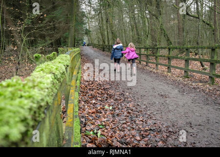 Due ragazze camminare in St Ives Estate in Bingley, Bradford, West Yorkshire. Foto Stock