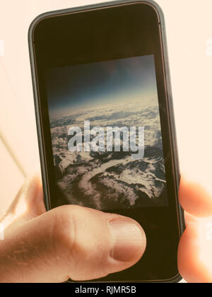 Closeup colpo di mano di raccolto utilizzando lo smartphone e scattare foto dal piano della pittoresca nuvole Foto Stock