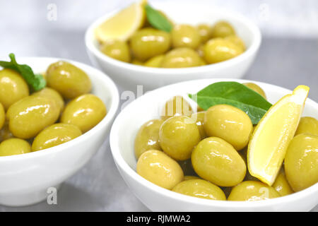 Tutto il green olive greche in una ciotola bianco. close up. Foto Stock