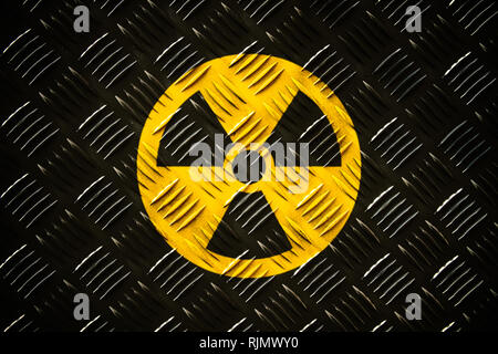 Radioattivo (radiazioni ionizzanti) rotondo giallo e nero simbolo di pericolo dipinta su un acciaio massiccio checker diamante metallo plat parete di pattern con scuri rus Foto Stock