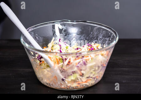 Rendendo coleslaw fatti in casa in un recipiente di vetro. Foto Stock