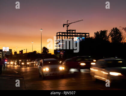 Il traffico nella strada americana di notte tramonto con silhouette di edifici in costruzione in background, Puebla, in Messico, nel gennaio 30, 2019 Foto Stock