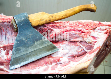 Grande ax per tritare la carne, di carcassa. Close up. Grande pezzo di carne. Professione di macellaio Foto Stock