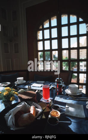 Didascalia: Udaipur, Rajasthan, India - Maggio 2003. Caffè, succo di cocomero e croissant a un tavolo per la colazione al Udaivilas, un nuovo Oberoi resort in Udaip Foto Stock