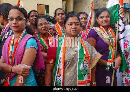 Femmina del Partito del Congresso i sostenitori di Mumbai, India, con bandiere e scialli del partito di simboli Foto Stock