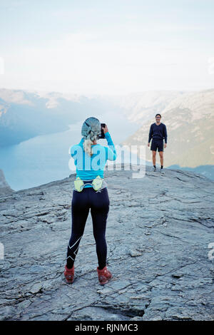 Instagram turisti - prendendo un telefono cellulare shot per i social media sulla sommità del pulpito Rock / Prekestolen o Prekestolen in Norvegia Foto Stock