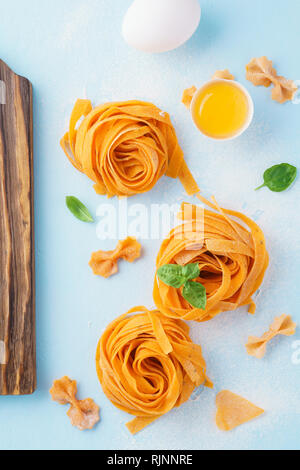 Freschi di pasta italiana, tuorlo d'uovo e basilico. Cibo sano concetto. Mediterranean Food concept. Foto Stock