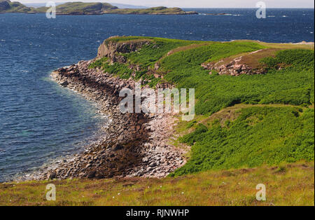 Una vista sul mare e le isole di estate da vicino Dornie, Polbain, Scozia su un soleggiato caldo giorno d'estate con il mare blu e un promontorio in primo piano Foto Stock