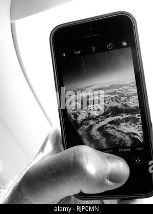 Stati Uniti d'America - 11 Maggio 2018: iPhone la fotografia dal piano - closeup colpo di mano di raccolto utilizzando lo smartphone e scattare foto dal piano della pittoresca nuvole Foto Stock