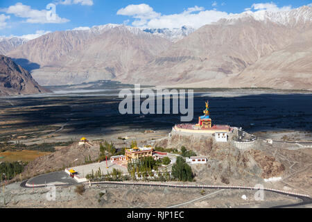 Paesaggio con statua di Ciampa (Maitreya Buddha) visto da Diskit Gompa (noto anche come Deskit Gompa), Valle di Nubra, Ladakh, Jammu e Kashmir India Foto Stock