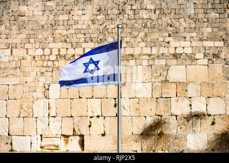 (Focus sulla bandiera) vista ravvicinata della bandiera Israeliana sventolata dal vento e la confusa parete occidentale in background. Foto Stock