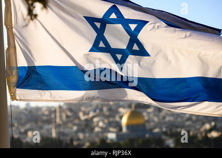 (Focus sulla bandiera) vista ravvicinata della bandiera israeliana con la confusa Cupola della roccia e Gerusalemme la città vecchia in background. Foto Stock