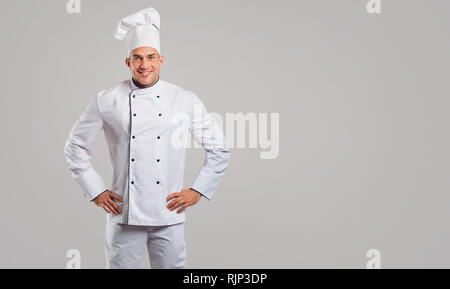 Chef in bianco uniforme è sorridente. Foto Stock