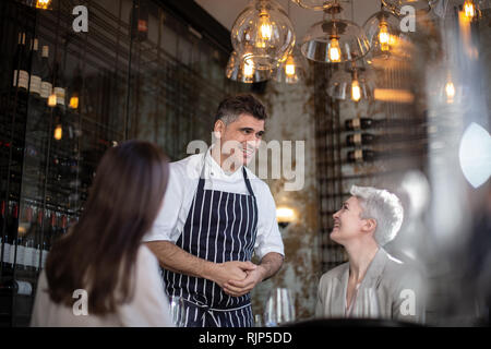 Lo Chef saluto i clienti nel suo ristorante Foto Stock