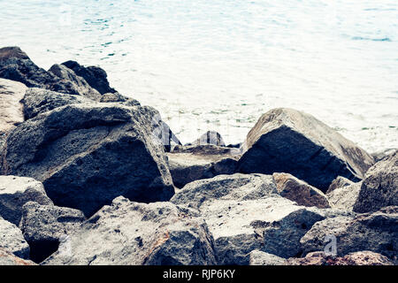 Mare roccioso riva di Acitrezza accanto alle isole dei Ciclopi, Catania, Sicilia, Italia Foto Stock