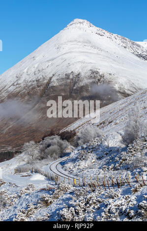 Coperta di neve Beinn Dorian e la singola traccia West Highland linea ferroviaria vicino ad Auch, Argyll and Bute, Scozia Foto Stock