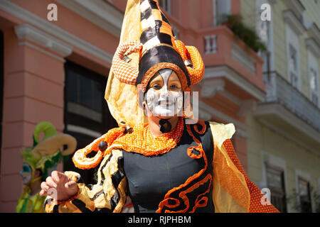 Un sorridenti street performer vestito in costume colorato intrattiene la folla per le strade di La Habana Vieja Cuba Foto Stock