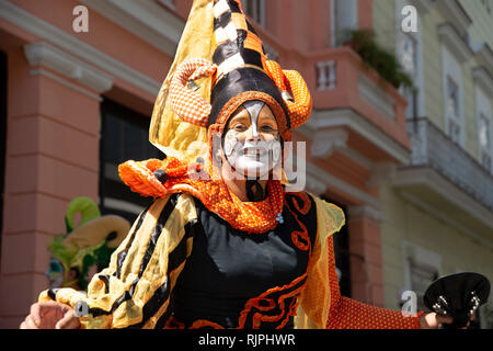 Un sorridenti street performer vestito in costume colorato intrattiene la folla per le strade di La Habana Vieja Cuba Foto Stock