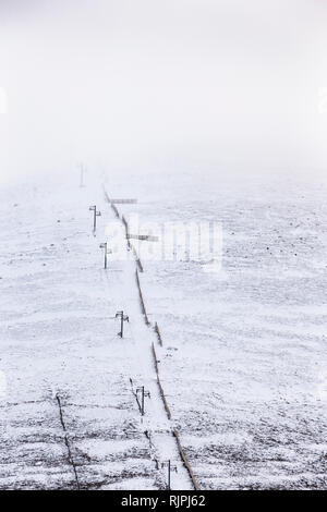 Impianti di risalita e neve sulla recinzione Cairngorm Mountain in Scozia. Foto Stock