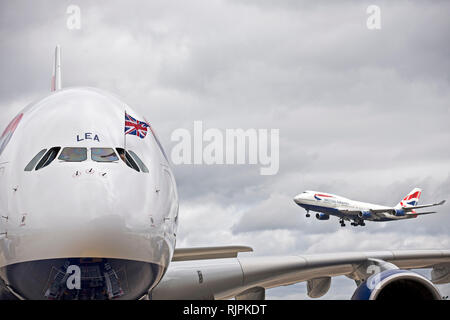 Un BA Boeing 747 terre (R) come un BA Airbus A380 (L) arriva presso l'aeroporto di Heathrow. Luglio 4, 2013. Foto Stock