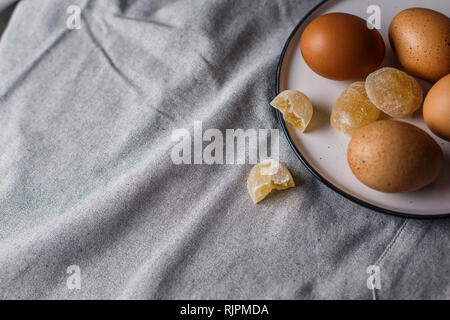 Su un piattino bianco sono uova sode e marmellata su una tovaglia di lino con copia spazio. Foto Stock