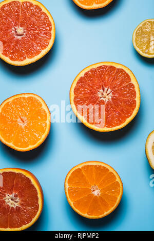 Tagliato a metà succosa agrumi su uno sfondo blu Foto Stock