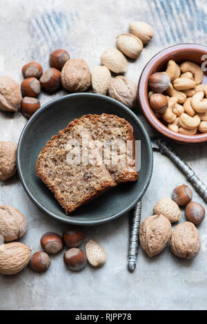 Noci e mandorle con guscio, noci di acagiù, nocciole, fette di torta Foto Stock