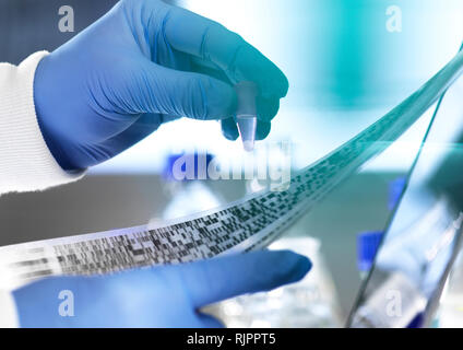 Research Scientist tenendo un campione in una fiala con risultati di DNA su gel autoradiogramma in laboratorio, stretta di mano Foto Stock