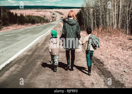 Madre e figli camminando lungo il tratto di strada in remoto, Ural, Sverdlovsk, Russia Foto Stock