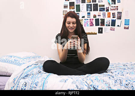 Adolescente di social networking sul letto Foto Stock