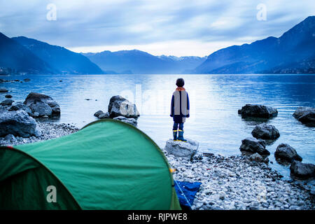 Ragazzo che guarda sul lago, vista posteriore, Lago di Como, Onno, Lombardia, Italia Foto Stock